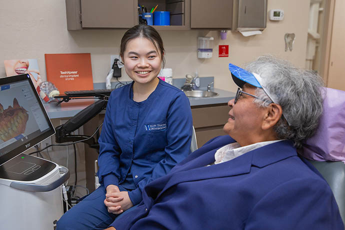 a dental staff discusses with a patient seated at a dental chair in Valley Dental and Orthodontics in Dublin, CA
