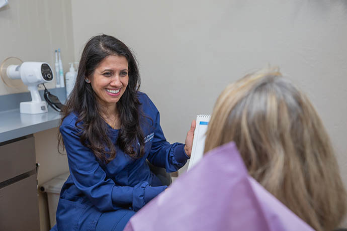 a dental staff shows a chart to a patient