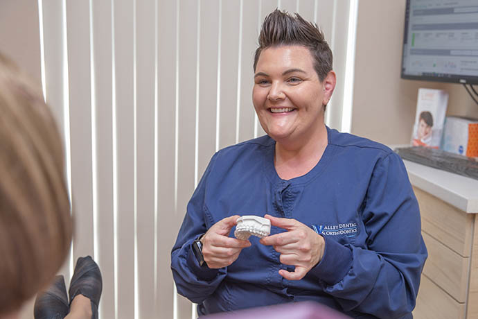 a dental staff shows a teeth impression to a patient